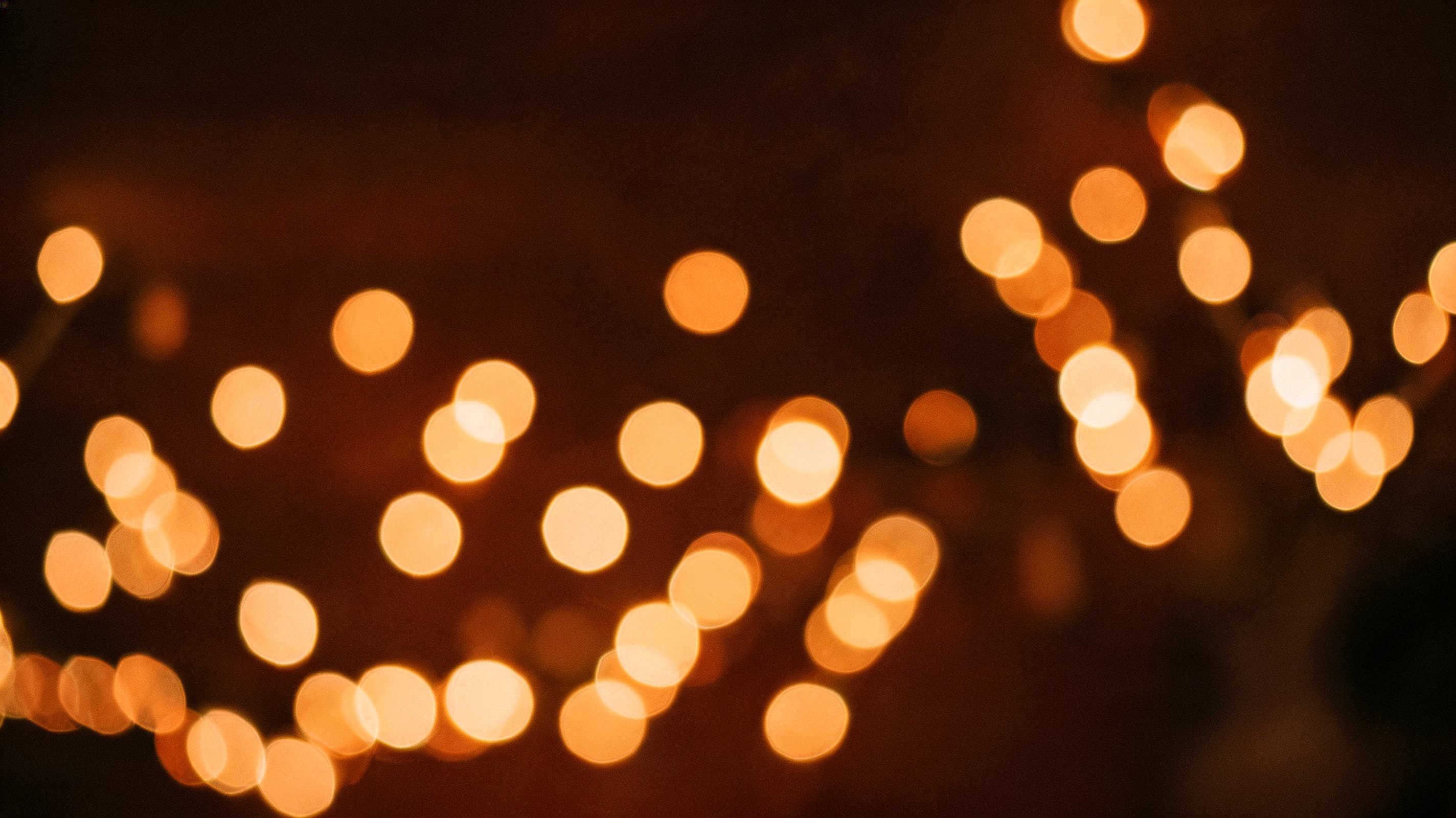Warme lichtjes die onscherp oplichten in een donkere ruimte.
